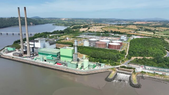 Establishing aerial shot of a power station on the River Suir in County Wexford, Ireland, surrounded by water, transport routes and farmland.