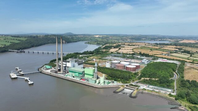 Elevated aerial view of an electricity generating station on the River Suir with surrounding estuary, shoreline and industrial facilities.