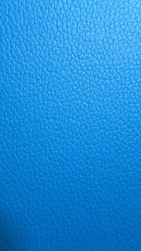 Blue textured leather surface with fine natural grain pattern and soft gradient lighting