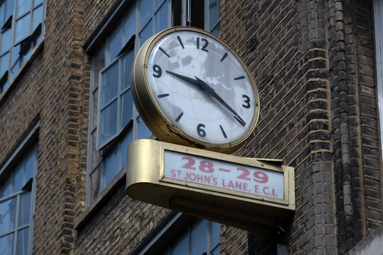 LONDON, UK - JULY 14, 20026:  Old vintage 1960s advertising sign with public clock for E Higgs Air Agency in St John's Lane, Farringdon