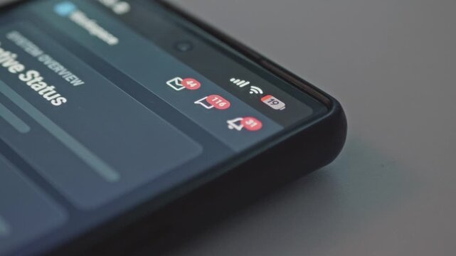 Macro view of cell phone displaying red notification icons with rapidly rising numbers, concept for incoming alerts, mobile app notifications, spam and constant online connection.