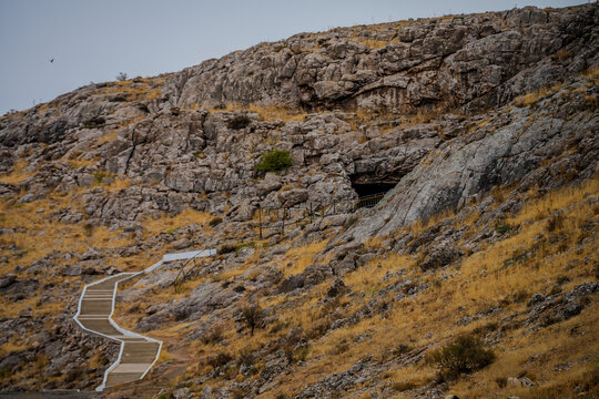 Winding path leading to a cave in the rocky hills of Baydibek District