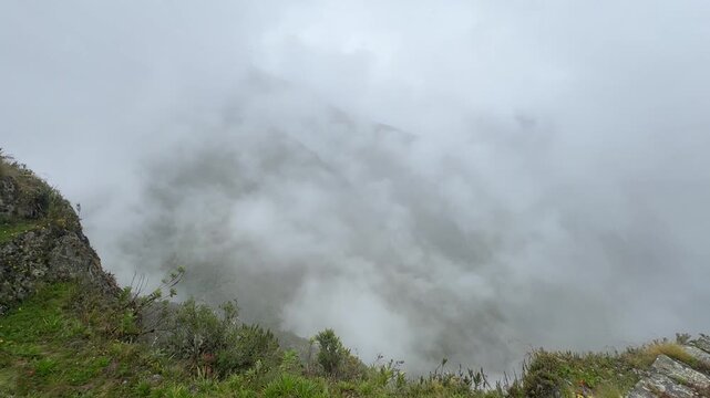Dense fog and clouds moving through a lush mountain valley along the Inca Trail in Peru