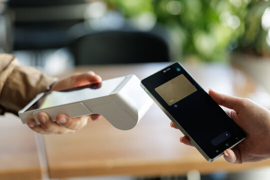 NFC payment with smartphone at wireless terminal in cafe