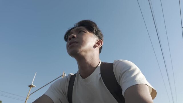 Young Asian Man Cycling Through Yogyakarta, Low Angle View