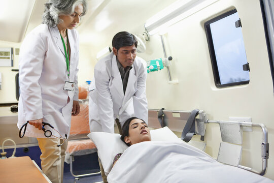Medical assistant taking patient out of ambulance