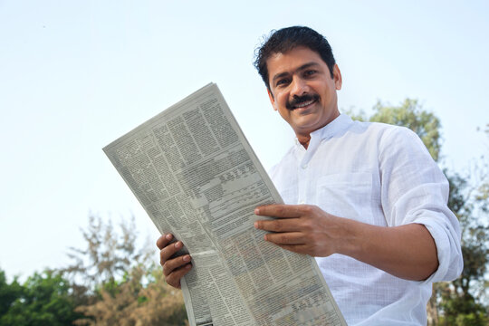 Portrait of a man with newspaper smiling
