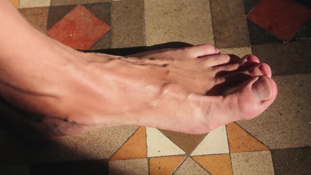 Close-up of a person placing a silicone toe separator between the toes. Helps reduce pressure and discomfort while walking, especially when wearing tight shoes. High quality 4k footage