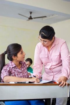 Teacher assisting student in classroom