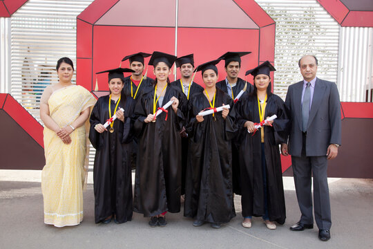 Portrait of graduate students standing with teachers