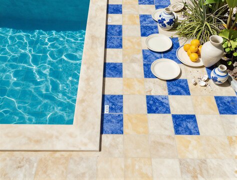 Swimming pool edge with blue tiles and citrus still life