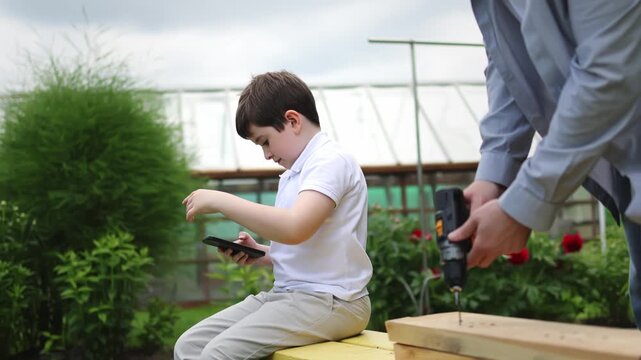 A child and a smartphone. A screwdriver. A man in a shirt. Slow motion video. High quality 4k footage