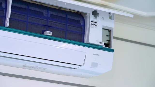 Zoom in shot of an open wall mounted air conditioner showing blue air filters for cleaning and home appliance maintenance
