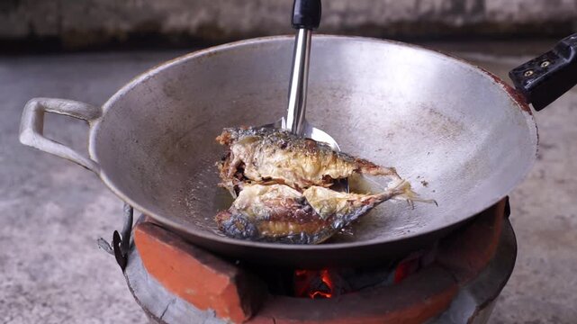 Traditional Thai cooking over charcoal, featuring spicy deep-fried fish and authentic local cuisine.