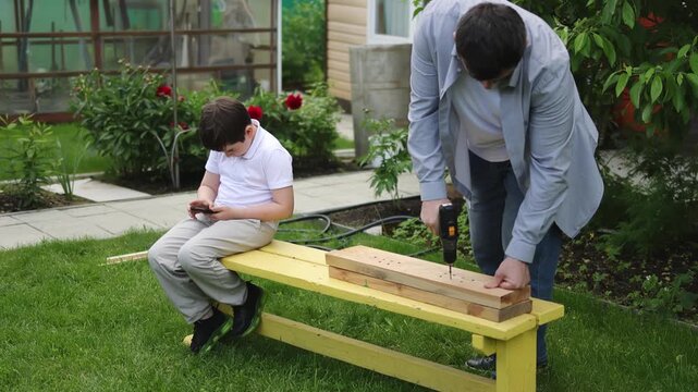 A child and a smartphone. A greenhouse near a house.A screwdriver. A man in a shirt. Slow motion video. High quality 4k footage