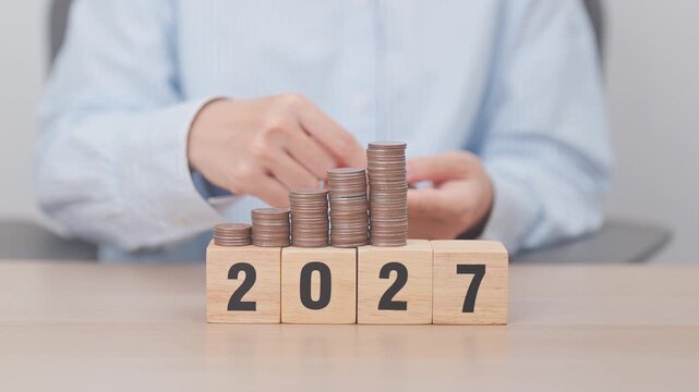 Happy New Year 2027 with Coins stack. Money, Budget, tax, investment, financial, savings and New Year Resolution concepts