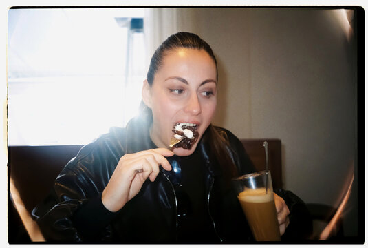 Woman enjoys a sweet dessert and coffee during a cafe break