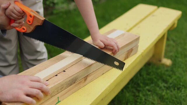 Hand saw. Wooden board. Father and son. Slow motion video. High quality 4k footage