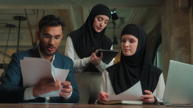 Arabian business team talking online video call laptop three dissatisfied upset office workers showing bad result low financial stats graphs Muslim businessman businesswomen discussing project failure