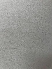 Fototapeta premium Textured concrete wall surface with subtle light and shadow variations for architectural backgrounds