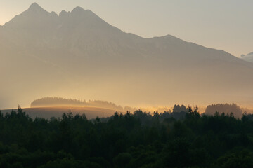 Naklejka premium lomnicky stit mountain peak in slovakia high tatras landscape view sunset misty glow nature rocky summit concept of travel, tourism, nature