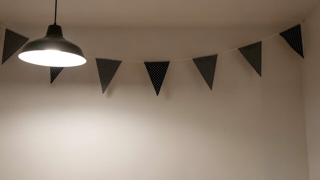 Black and white patterned bunting flags hanging in a room with pendant light