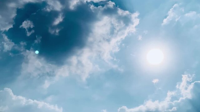 Real-time footage of brilliant sunlight filtering through soft white clouds across a blue sky, with a gentle right-to-left camera movement for nature, travel, wellness and cinematic projects.