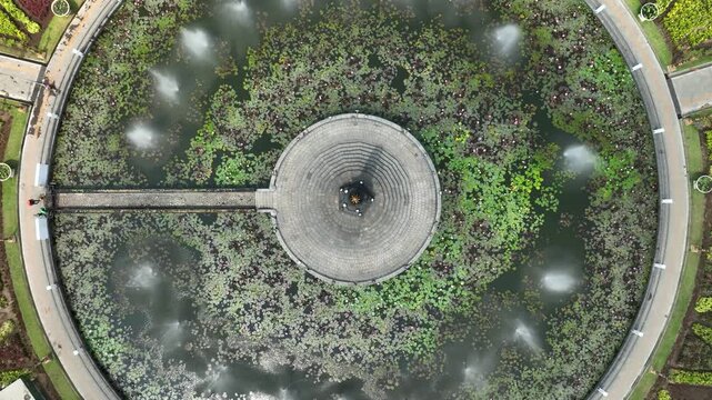 Aerial view rising over Alun-Alun Tugu roundabout, central monument, and gardens in Malang