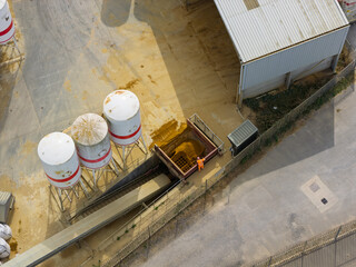 Worker Cleaning a Metal Grate at an Industrial Sand Facility During the Sunny Morning © Tom