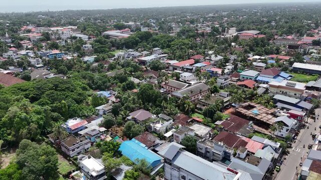High-altitude aerial drone shot capturing a wide view of Alappuzha town around Civil Station Ward and Mullakkal along CCS SB Road. Features colorful rooftops, lush trees, and street networks.