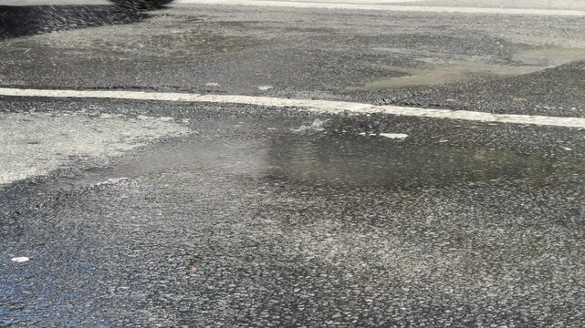 High-pressure water gushing from ruptured underground pipe, flooding asphalt and halting traffic; perfect for news stories, infrastructure reports, and emergency planning materials
