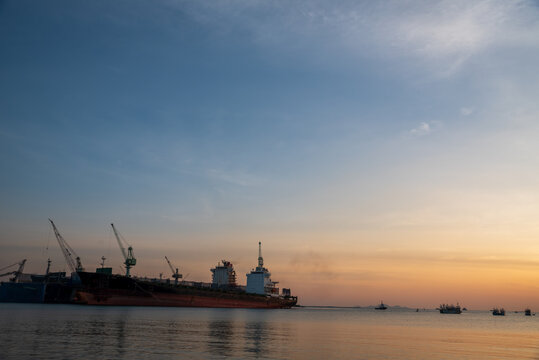 Industry landscape on sunset Engineering shipping crane depot at logistic export terminal control. Silhouette Warehouse freight background container yard loading quayside harbor port with copyspace