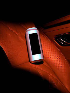 Low-key shot of soda can lying on orange seat inside luxury sports car with deep shadows. Refreshing lemonade in a sealed metal container.