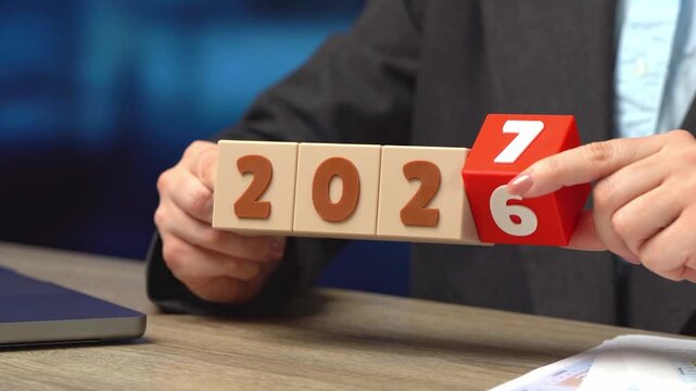 A businesswoman turns 2026 into 2027. Business plans and economic forecasts. Strategic vision, market expectations and financial planning. Corporate strategy content, investment and future trend