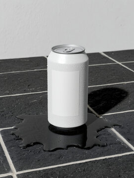 White can with light label standing on black tiled floor slightly covered in water. Classic highly carbonated drink in a tin packaging.