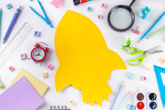 Back to school Background with Rocket frame drawing with School Supplies  with notebooks, Pen, Pencils, Magnifying Glass, Eraser, Paper Clip, Paints, flat lay banner top view copy space