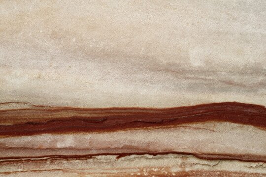Close-up abstract of flowing bands of beige, white, and deep red earthy rock textures