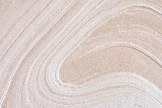 Swirling pattern texture on beige colored sand