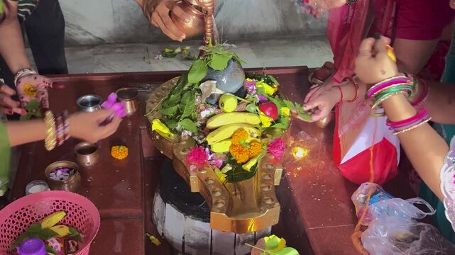 Devotees Performing Abhishekam Ritual With Flowers Fruits and Holy Water