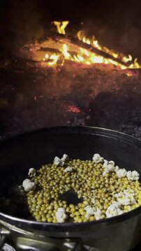 Cozy Outdoor Cooking: Popcorn Prep by the Fire
