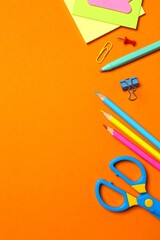 Flat lay withschool stationery on orange background, top vertical view. © Sunlight