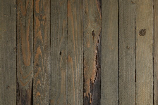 Old wooden fence or wall cladding with distinctive woodgrain and knots in full frame background texture