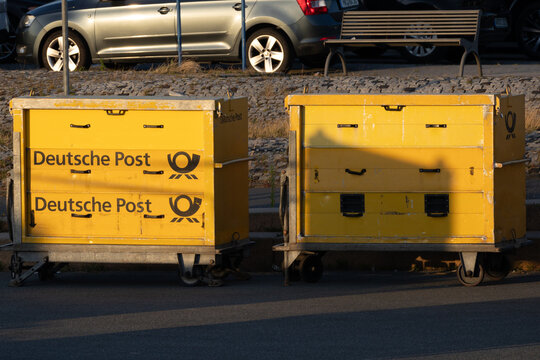 Deutsche post yellow mail trolleys awaiting delivery service in germany