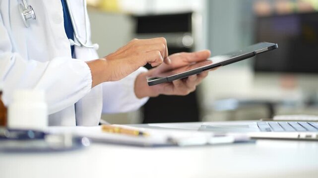 Medical students working on laptop computer and tablet and medical stethoscope on clipboard on desk, electronics medical record system EMRs concept.