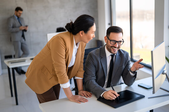 Two happy diverse multiethnic business team people working, talking in corporate office