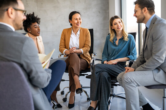 Multicultural professional businesspeople working together on research plan in boardroom.