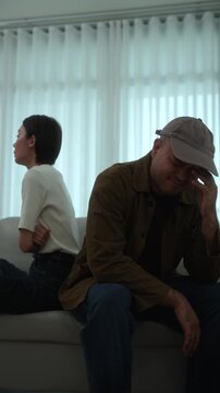 Heartbroken couple sitting apart after an unresolved family conflict at home. Relationship challenges, emotional stress. Communication breakdown, financial pressure. Mental wellbeing and marriage.
