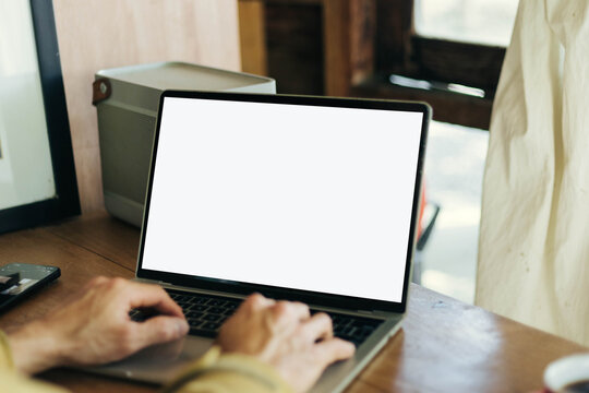 computer screen blank mockup.work using laptop with white background for advertising,contact business search information on desk at coffee shop.marketing and creative design