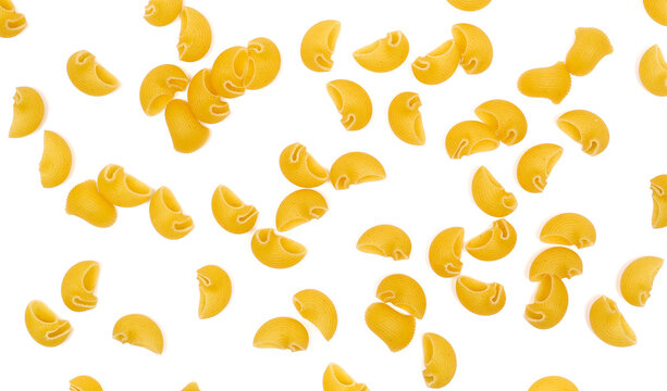 Dry yellow pipe rigate pasta with ribbed, curved shapes pile isolated on white background, top view
