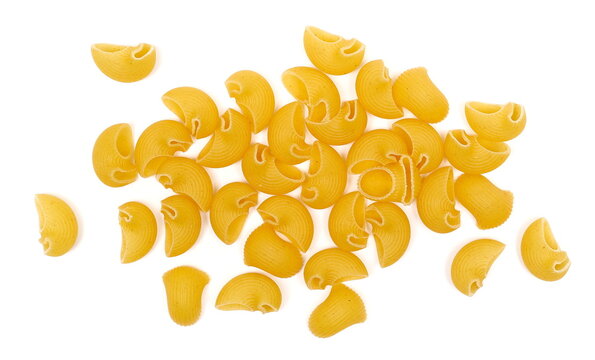 Dry yellow pipe rigate pasta with ribbed, curved shapes pile isolated on white background, top view